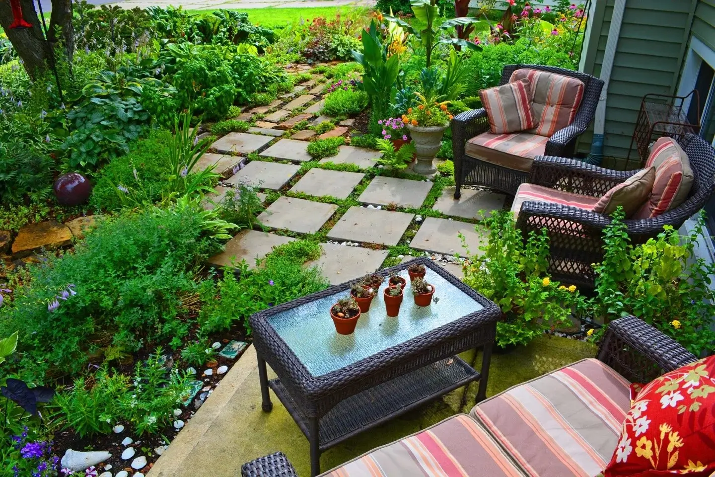 A cozy patio with comfortable seating and green plants.