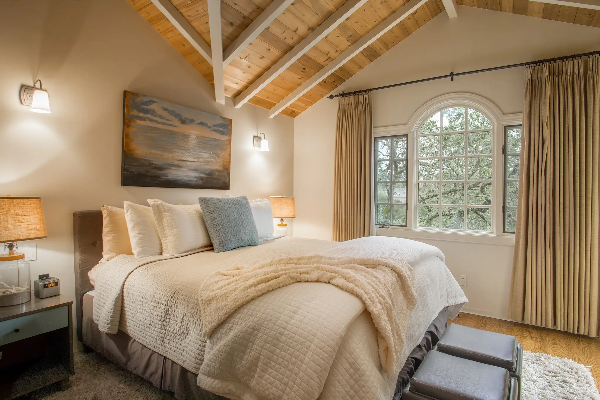 A peaceful bedroom with natural light and soft bedding.