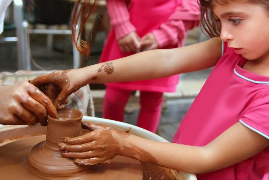 Hands carefully crafting a piece of pottery.